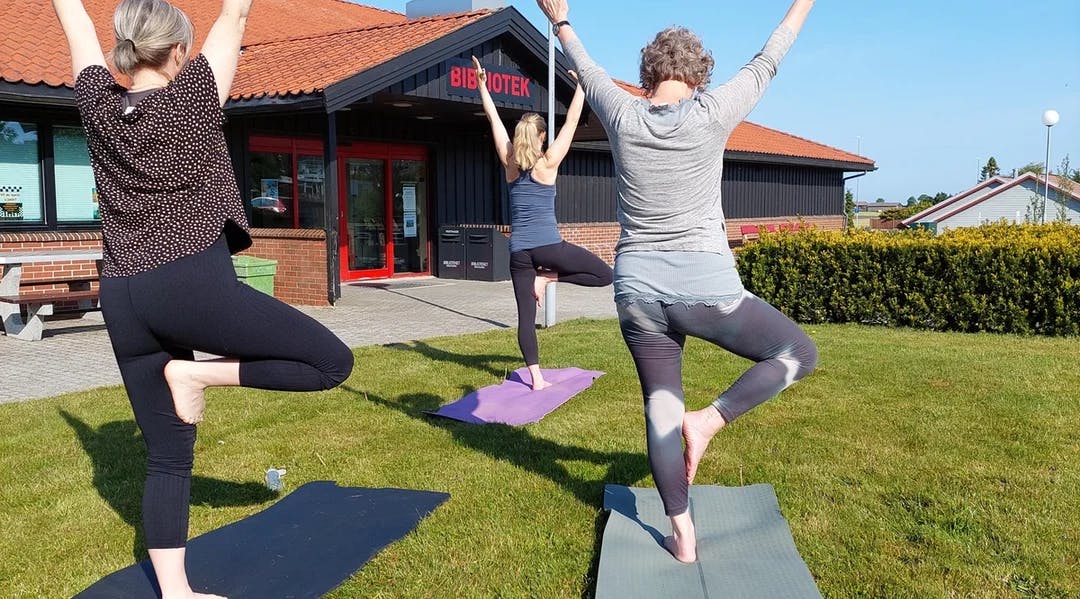 Tre personar i yoga-stillinga "Treet"