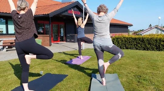 Tre personar i yoga-stillinga "Treet"